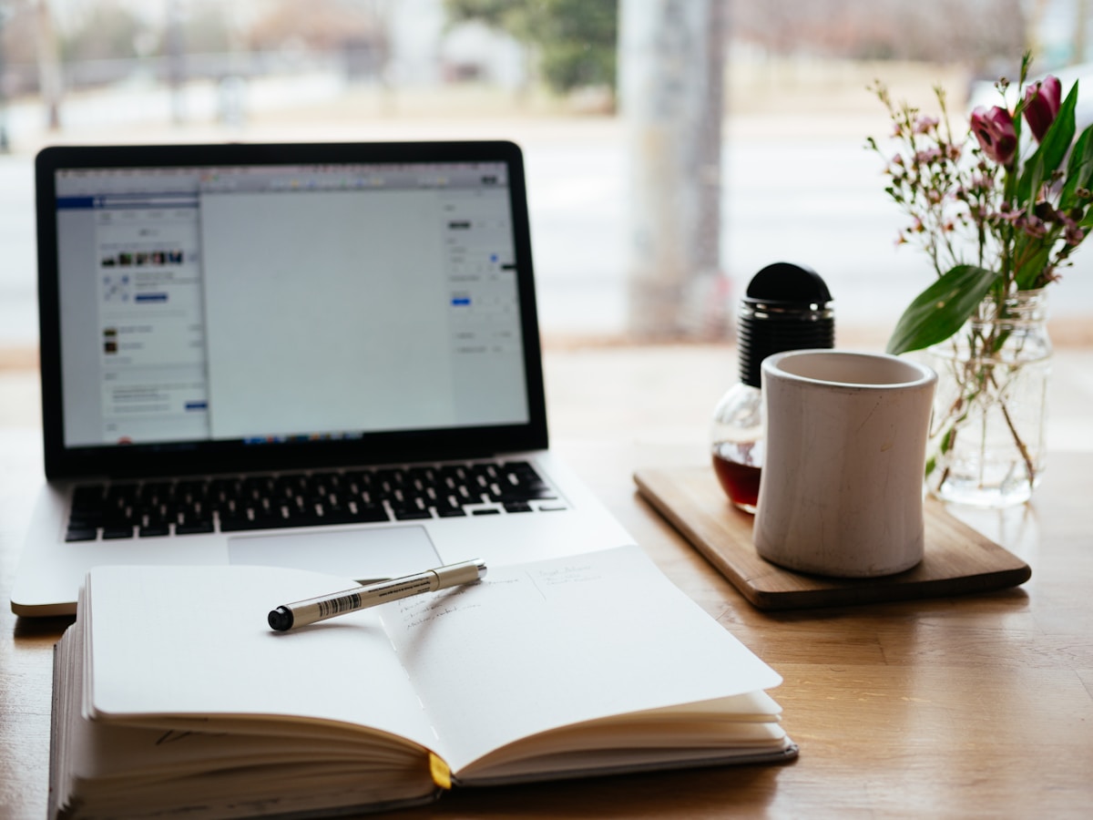 Laptop and open notebook on a desk