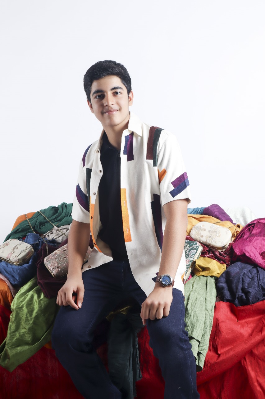 Yohaan Shodhan seated beside colourful fabrics